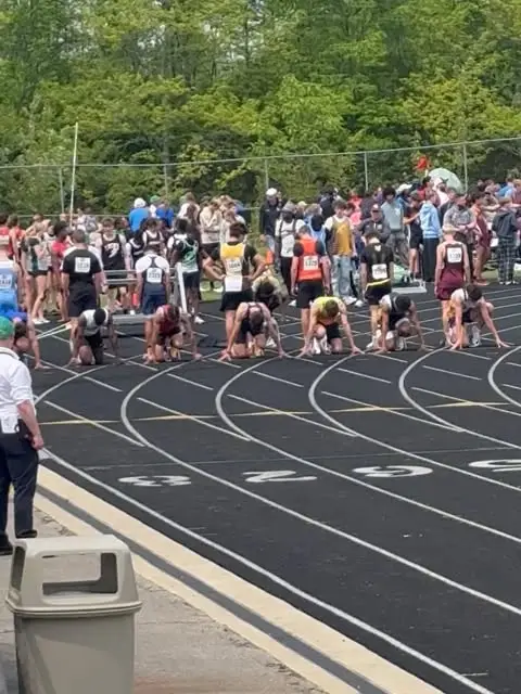 Sprinters in starting blocks at an outdoor meet start line
