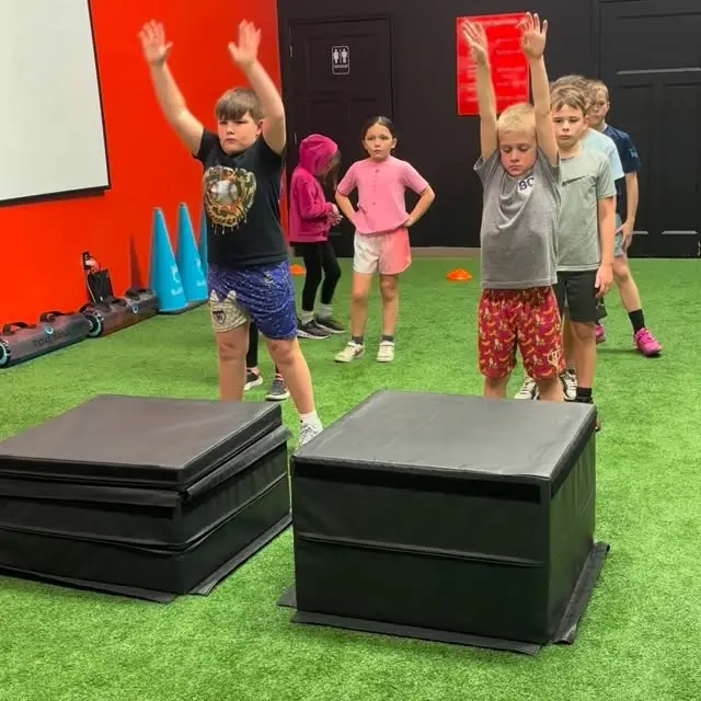 Young athletes doing jump drills by the plyo boxes