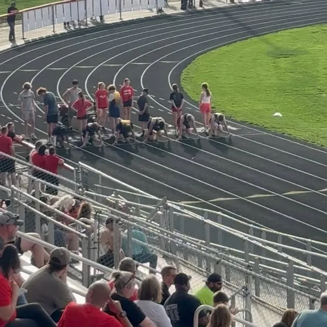 Momentum Track Club athletes lining up on the start line at a summer meet